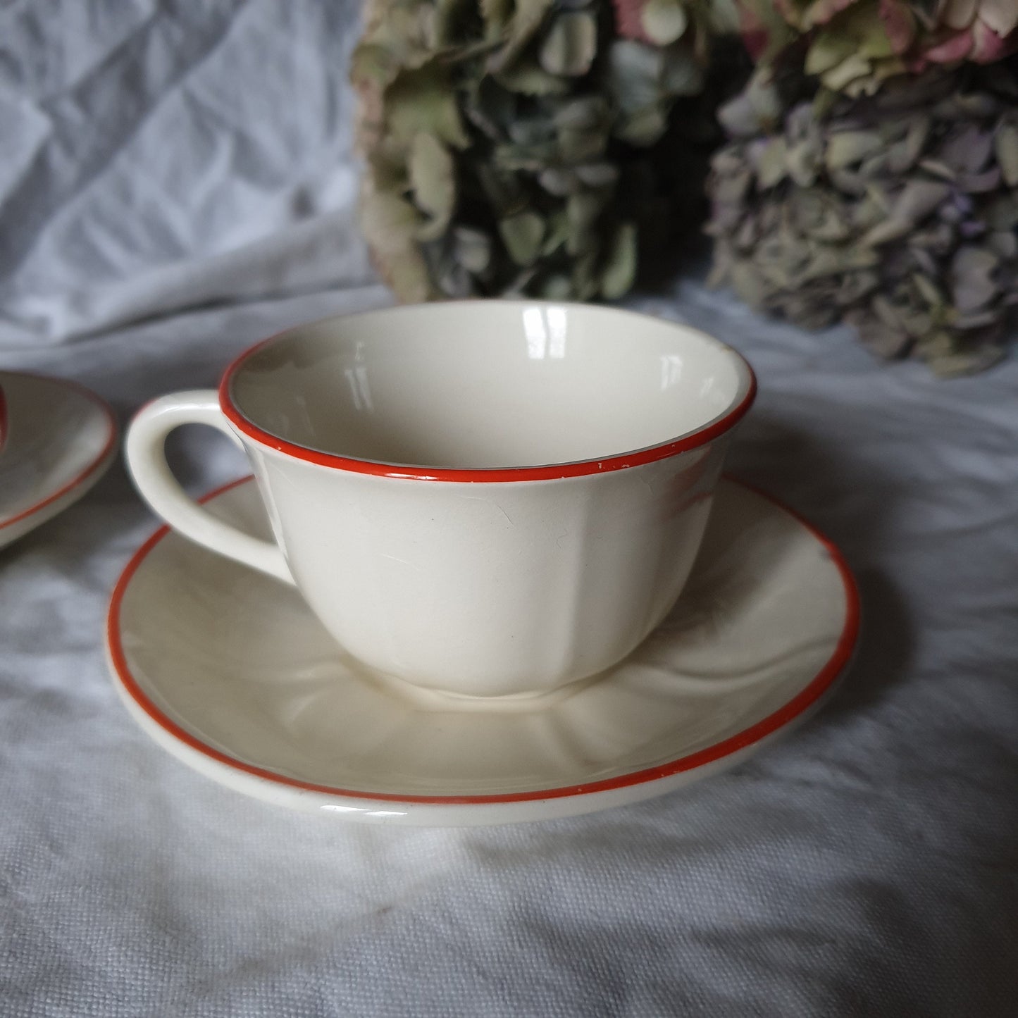 PAIR K&G Luneville French cups w saucers, early Art Deco, c1910-20 red and white w subtle pearlescent finish, hand painted French faience
