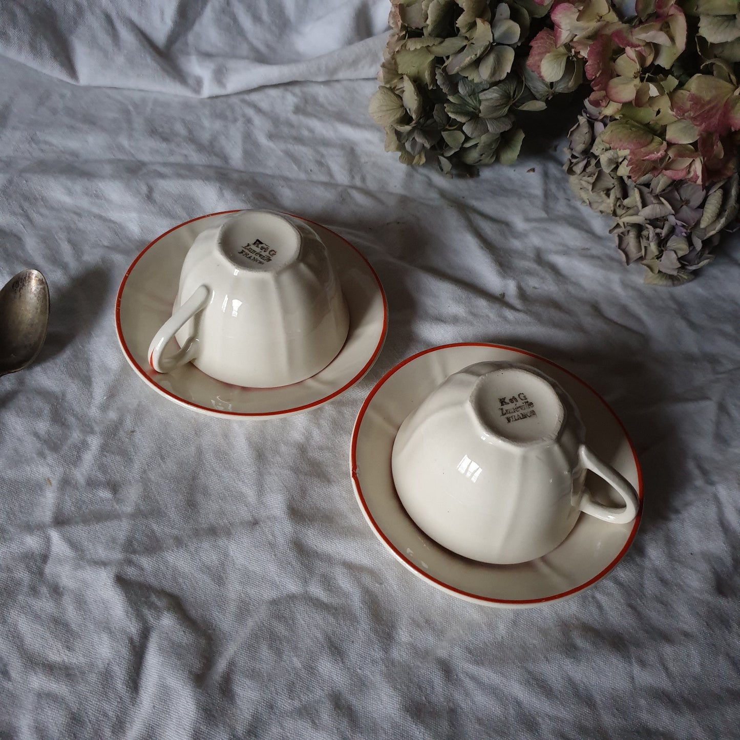 PAIR K&G Luneville French cups w saucers, early Art Deco, c1910-20 red and white w subtle pearlescent finish, hand painted French faience