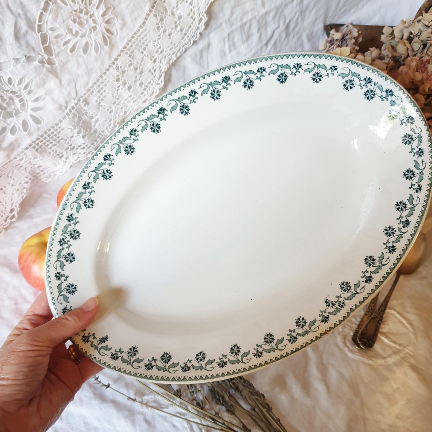 French antique oval platter in green transferware being held in hand to show scale. Georgette pattern c1900