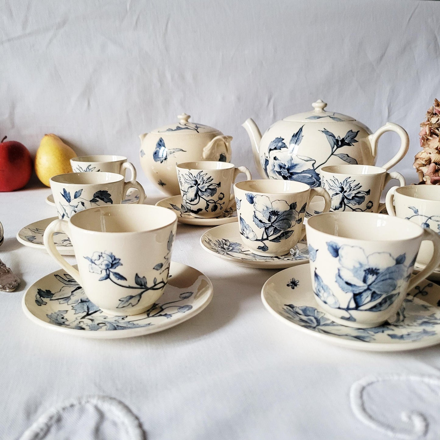 A close up view of a Gien French antique ironstone tea set, in terre de fer to show the non repeating floral blue transferware patterns
