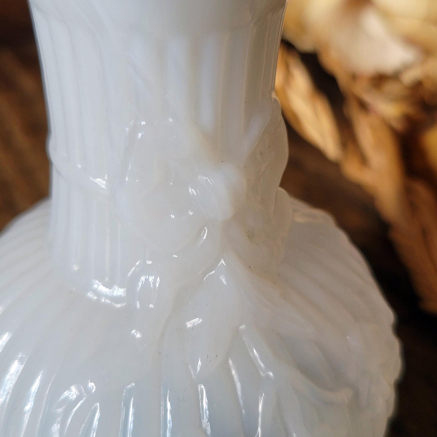 Close up of small antique French white opaline milk glass vase, showing ribbon design