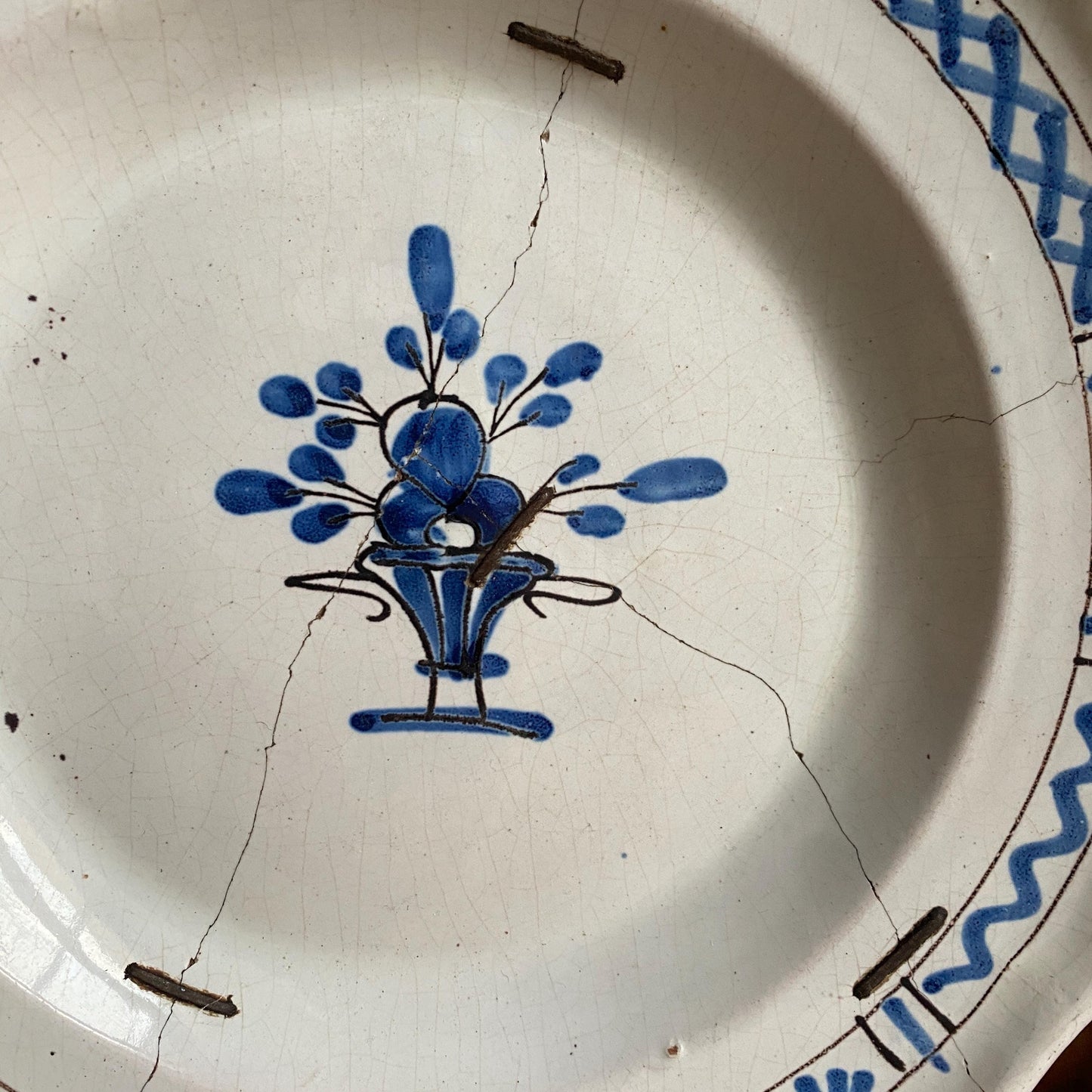 Antique round cul noir platter basket of flowers design with staple repairs. Rouen France c1880